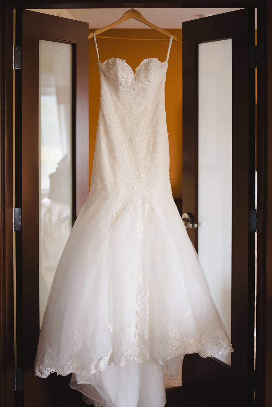 wedding dress hanging from a doorway 