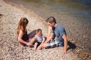 family sitting on the beach in peachland