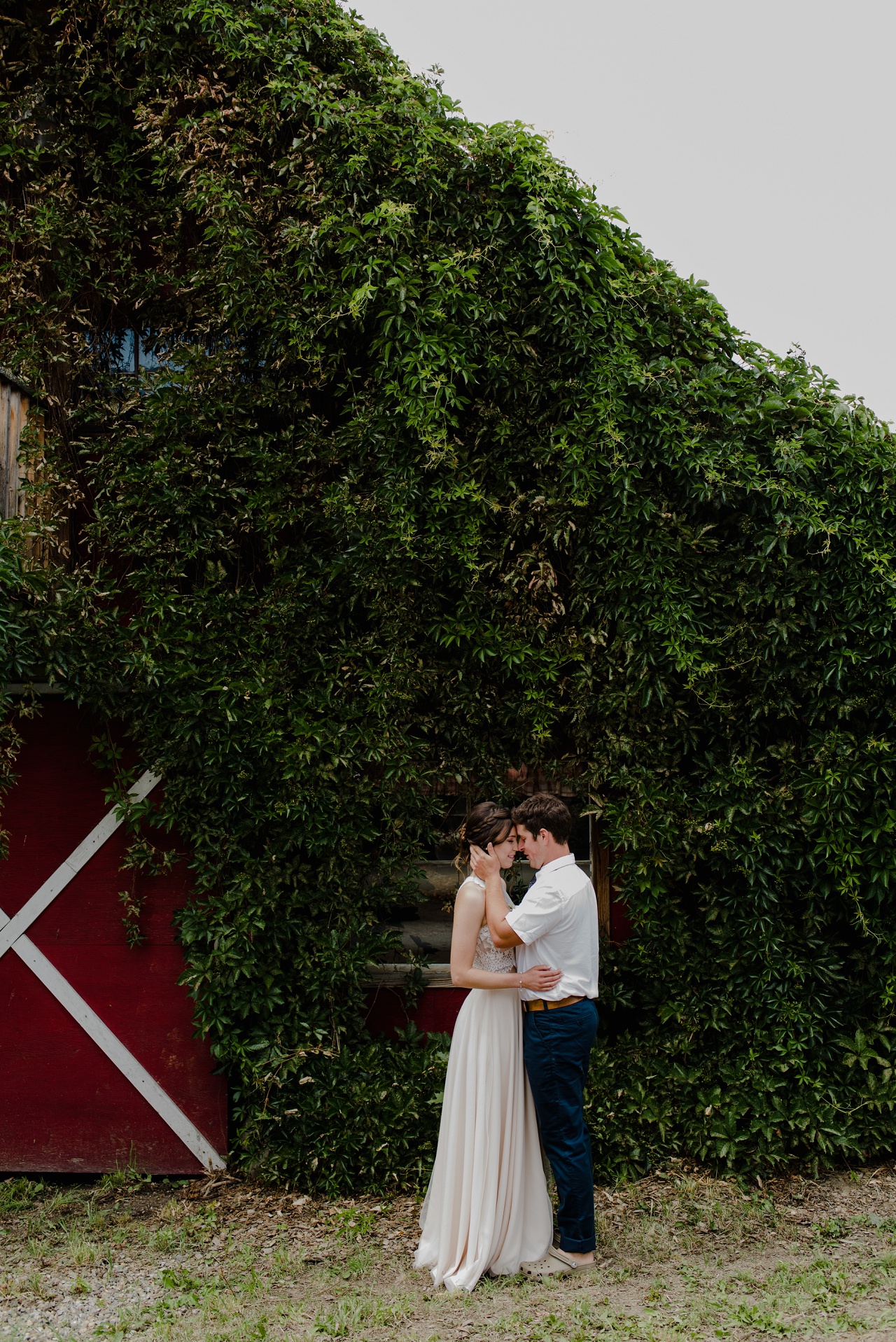 Bride and groom in front of a barn at Sproule's Farm, Lake Country