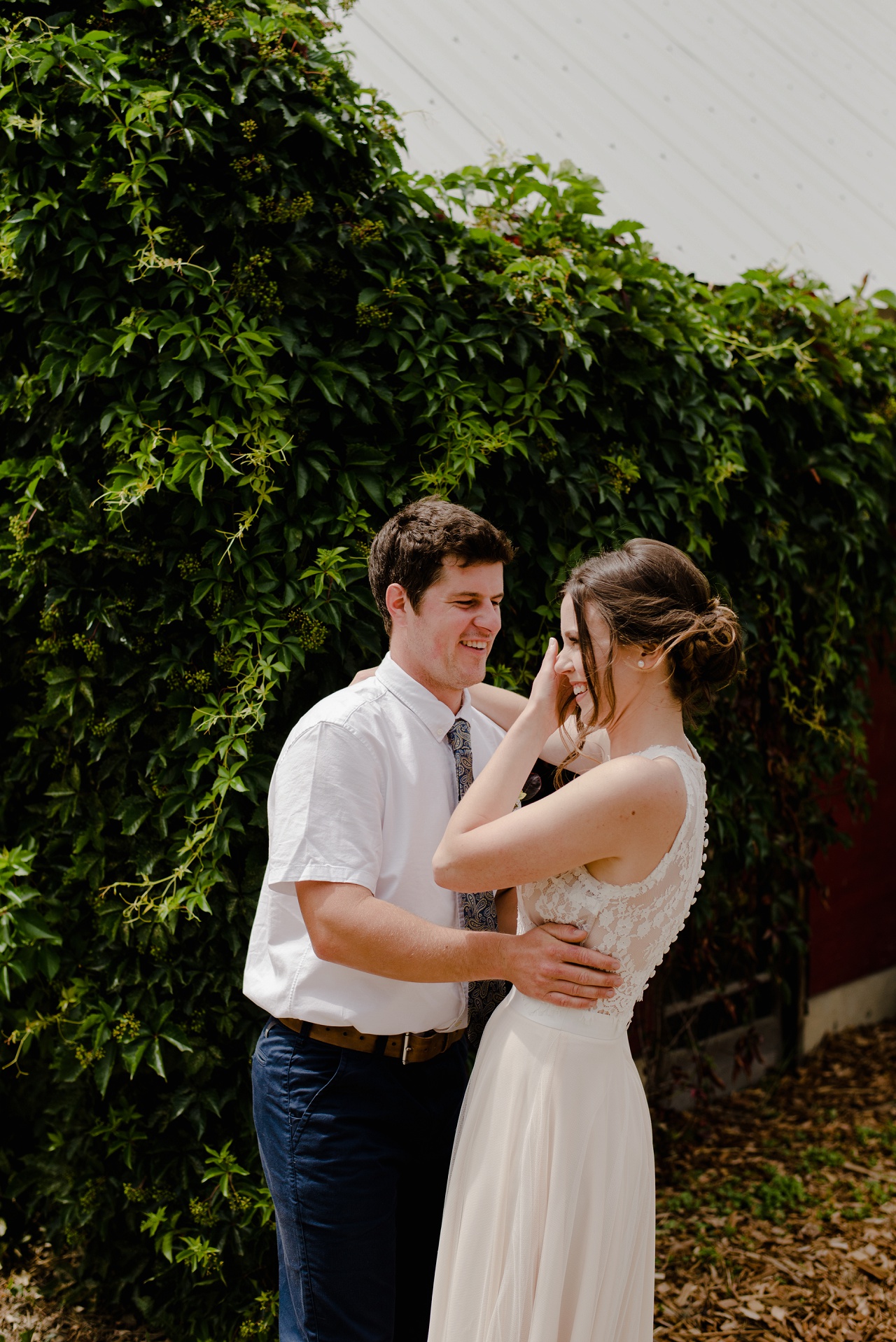 Bride and groom's first look photos in front of a barn in Lake Country